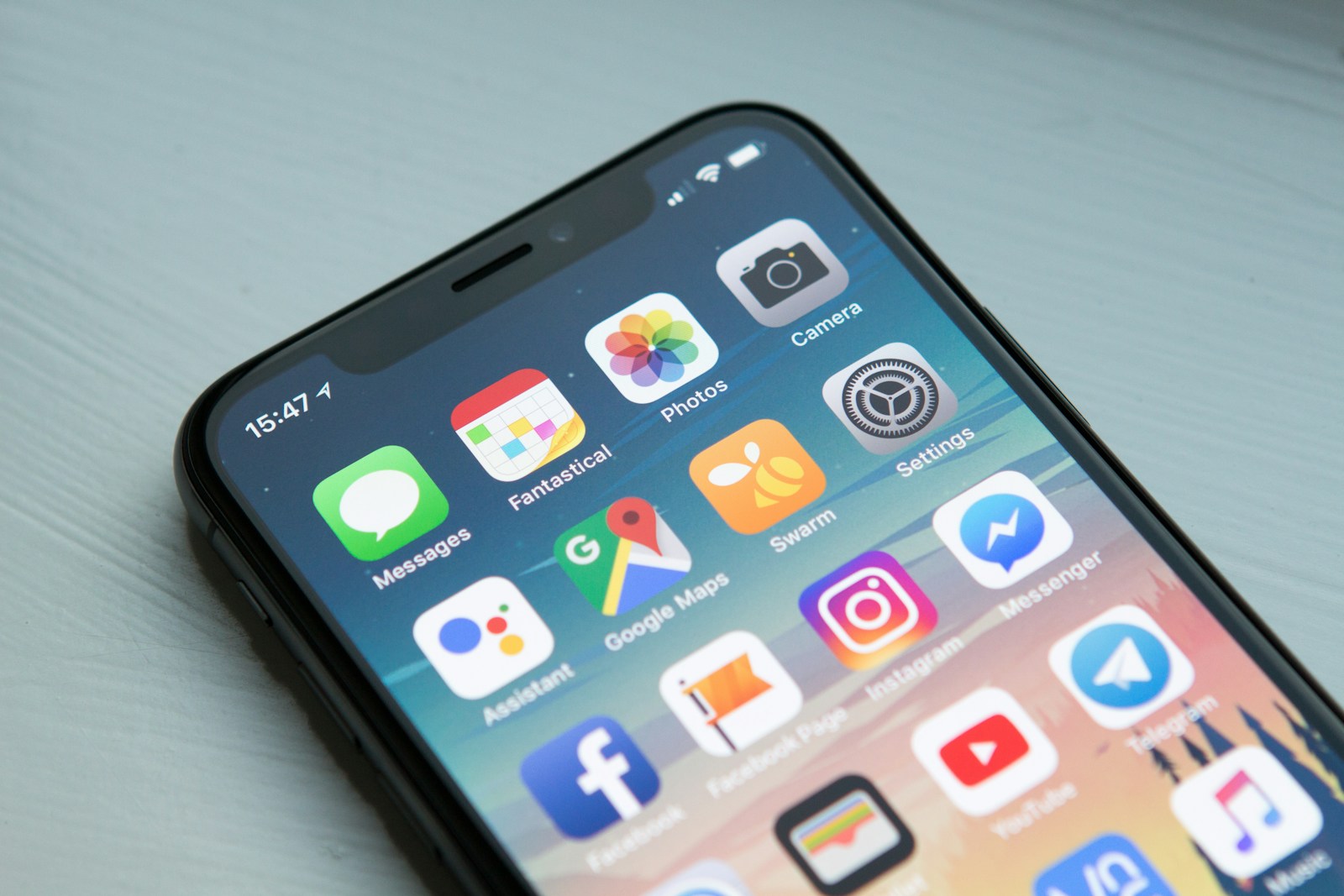 Space gray smartphone showing app icons on screen