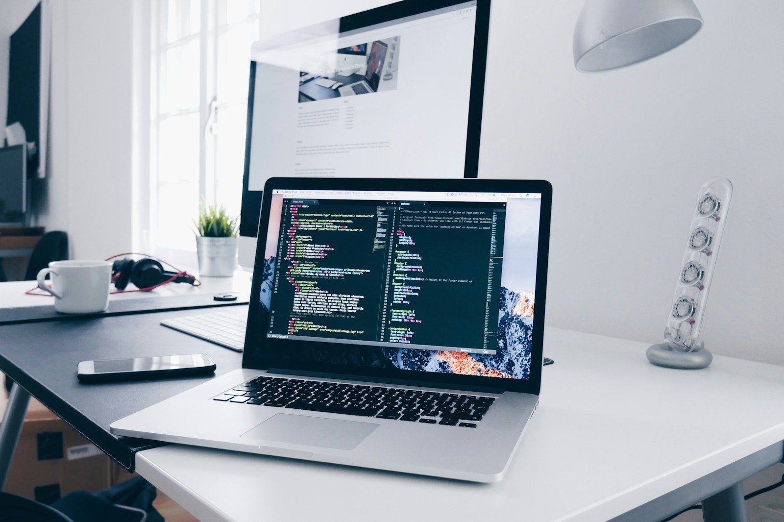Laptop on a desk with programming code on screen